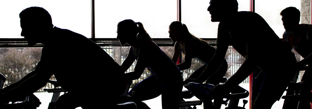 Participants of a group cycling class on stationary bikes