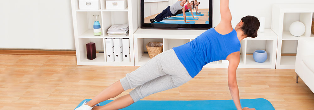 Woman following fitness instructions on a TV