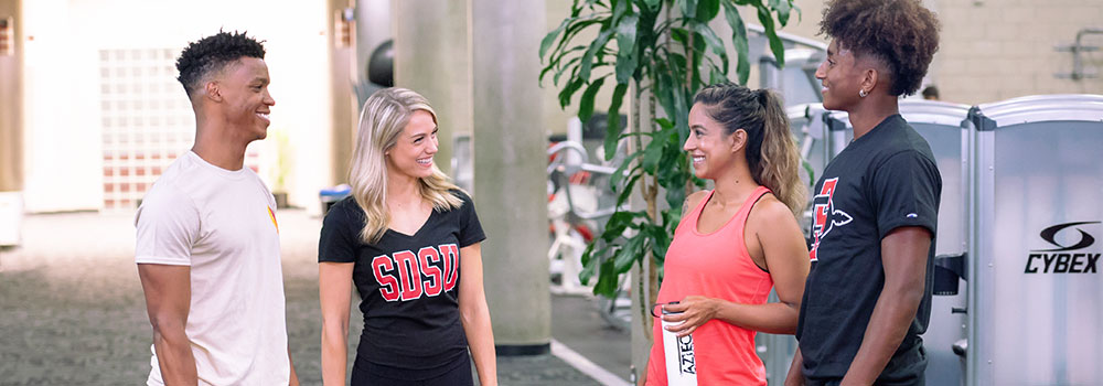 Four cmiling SDSU students in ARC hallway
