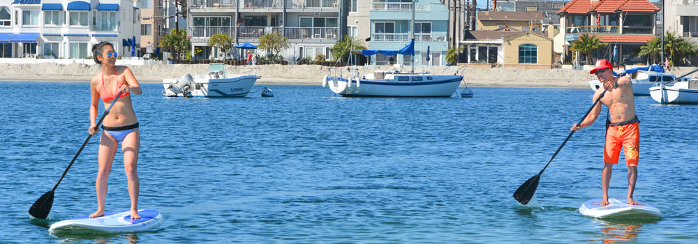 Students standing on paddle boards on the ocean